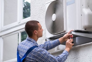 man working on window air conditioner