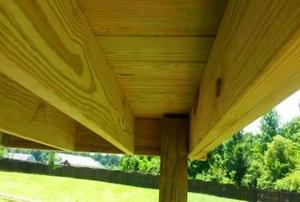 The badly built underside of an out of code deck.