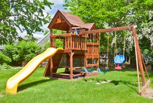 A wooden playset in a private backyard.