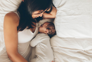 woman and baby laying in bed