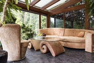 sunroom with natural design elements including couch, coffee table and large plant
