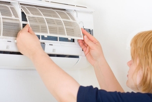 A woman installs a split heat system.