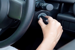 a hand putting a key in a car's ignition