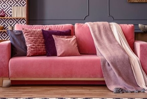 pink couch with pillows and blanket