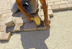 man installing stone pavers