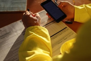 construction worker filling out work permit with phone