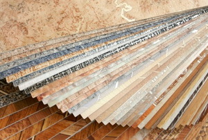 A stack of many different designs of vinyl flooring tiles.