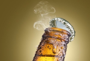 The top pops off of a cold bottle of beer.