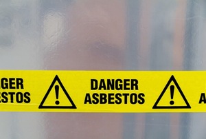 Yellow tape with the words "danger asbestos" on it.