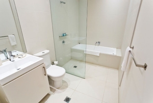 A bath/stand-up shower combo in a white bathroom.