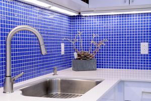 kitchen counter with walls of small blue tile backsplash
