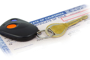 A key and key fob sit on top of a California state car title.
