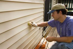 A man works on siding.