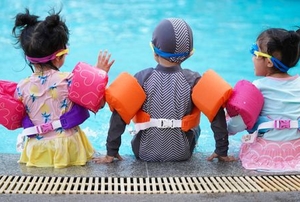 Three kids at a pool.