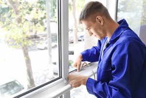 A man works on double pane windows.