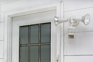 A back or side door with motion detector security lights installed beside it.