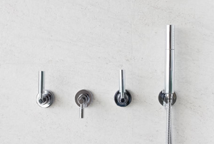 3-handle shower faucet on a shower wall
