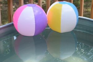 beach balls in a stock tank pool on a deck