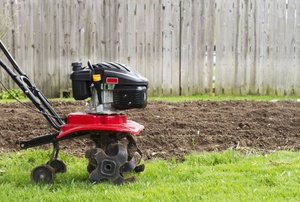 A tiller working on soil.