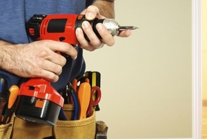 man with tool belt holding cordless drill