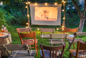 Chairs on a lawn in front of an outdoor movie screen
