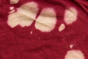 Bleach stains on a red shirt.