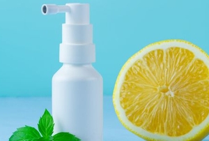 spray bottle with cut lemon and sprig of mint