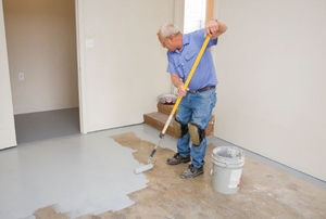 A diy-er painting a wood floor.