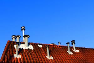 A red-tile roof with a copious amount of pipe-style exhaust vents.