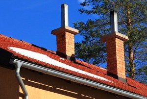 red roof, two chimneys, and aluminum gutter on house