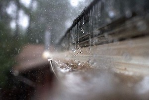 Heavy rain falls into a rain gutter.