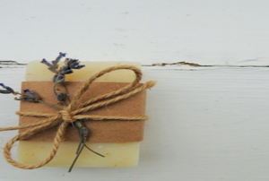 A piece of homemade organic goat milk soap tied with a piece of lavender and twine.