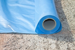 A roll of blue plastic sheeting used for a crawlspace vapor barrier.