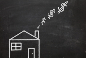 a chalkboard drawing of a house with dollar signs coming out the chimney