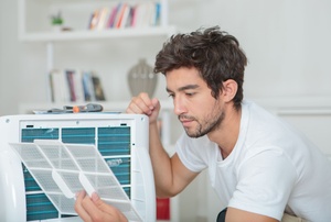 A man sets up a room AC unit.