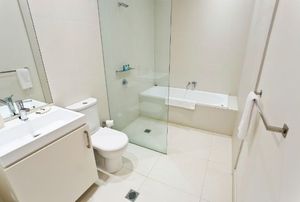 A bathroom with frameless shower door.