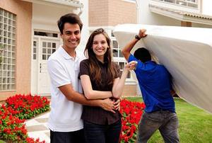 Real estate: couple moving house, mover carries mattress