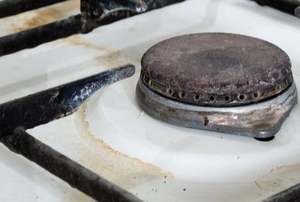 rusty gas stovetop with spilled water