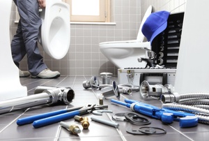 Plumbing tools near a toilet.