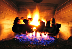 A close-up of logs burning in a fireplace.