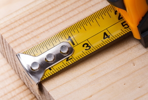 extended tape measure on raw wood plank