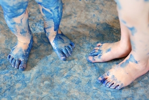 children's feet and linoleum floor splattered and stained with blue paint