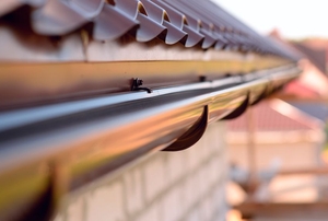 A length of rain gutter secured to the eaves of a roof.