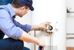 repairman adjusting temperature on a water heater