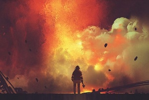 A man walks in front of a fire.