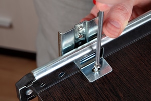 Screwing the hardware on a pull out shelf
