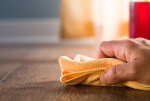 hand cleaning hardwood floor with rag