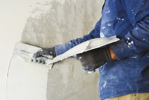 Applying a skim coat of compound to a wall