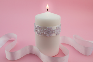 White candle with lace wrapped around it