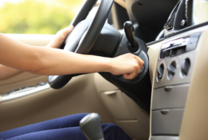 woman turning the key in the ignition of a car